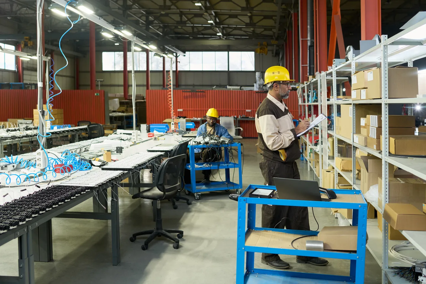 Warehouse operator reviewing inventory beside industrial shelving