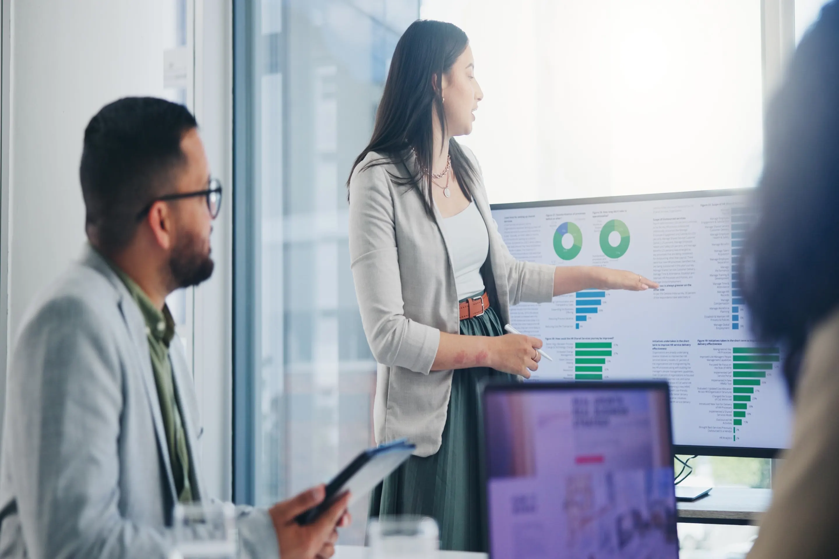 Business professionals reviewing analytics in a glass-walled office
